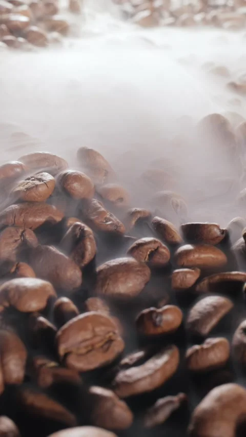 Steaming roasted coffee beans background with selective focus. Stock Footage 346393259