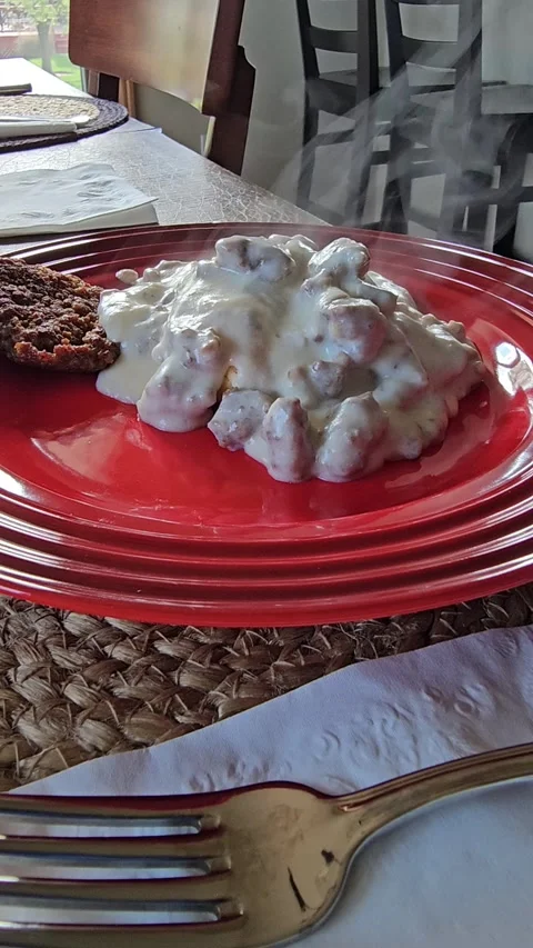 Steaming savory biscuits and gravy breakfast meal plate vertical video Stock Footage 335971778