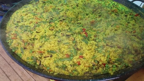 Steaming seafood paella in large pan cooked at outdoor restaurant Stock Footage 83244632