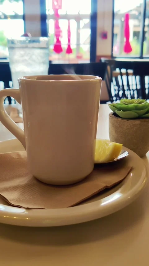 Steaming tea of coffee mug hot beverage on a restaurant table vertical 4k Stock Footage 267862610