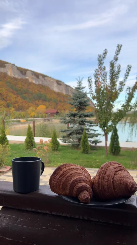 Steaming tea with croissants poured into rustic mugs Stock Footage 304879330