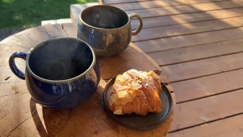 Steaming tea with croissants poured into rustic mugs Stock Footage 304879531