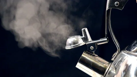 Tea kettle with boiling water on a black background, Stock image