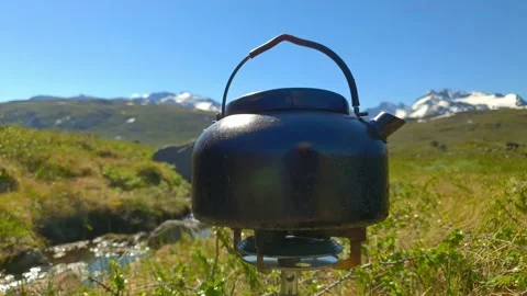 Steaming tea kettle in mountain terrain in Norway Video stock 156788604