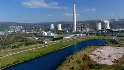Steaming thermal power plant behind the lake with an old excavator, a Vídeos de archivo 200375107
