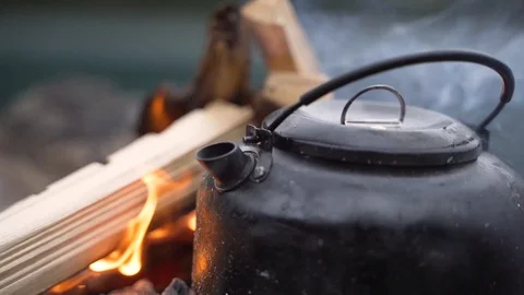 Steaming Watter Jug on a burning fireplace outdoors camping closeup Stock-Footage 120190412