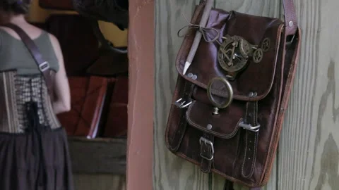 Steampunk Leather Messenger Bag Hanging in Renaissance Shop Stock Footage 345279155