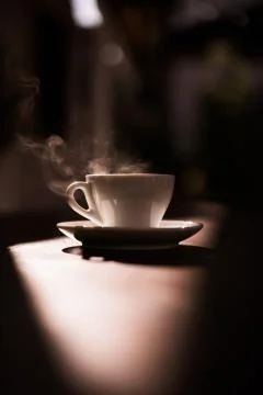 Steamy coffee cup in the sunlight Stock Photos