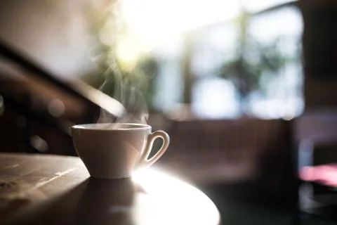 Steamy coffee cup in the sunlight Stock Photos