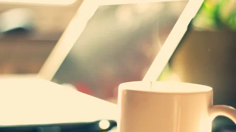 Steamy cup of coffee or tea with laptop in background Stock Footage 949259