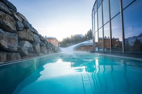 Steamy infinity pool and spa beside snowy pistes in Oberlech, Austria Stock Photos
