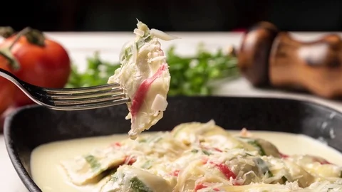 Steamy multi-colored ravioli pasta in a black iron pan Stock Footage 116920531