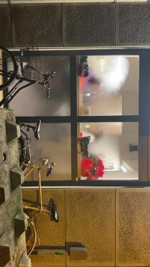 Steamy window of a restaurant kitchen with bikes parked outside at night Stock Footage 302758628