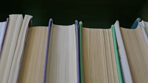 Stedicam shot, 4K. Camera moves along shelf filled with paper books. Stock Footage 157257571