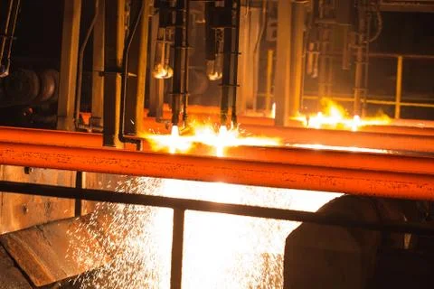 Steel Billets at Torch Cutting. Hot square steel bloom on the roll-table. Stock Photos