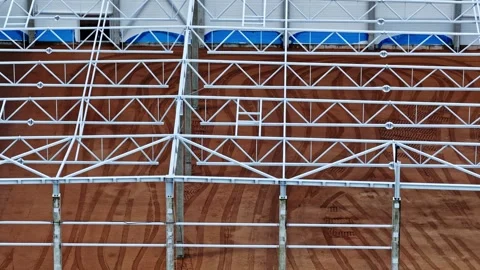 Steel Building Framework Over Red Dirt Ground at Construction Site With Tire Vídeos de archivo 337748168