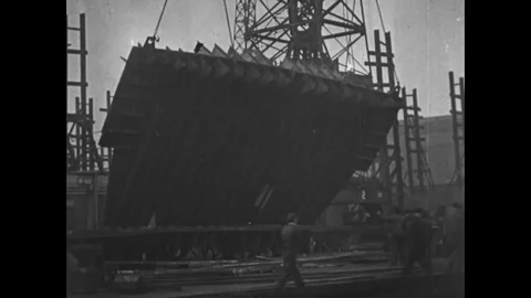Steel bulkhead raised by a crane to build a ship - 1917-1918 Stock Footage 83686992