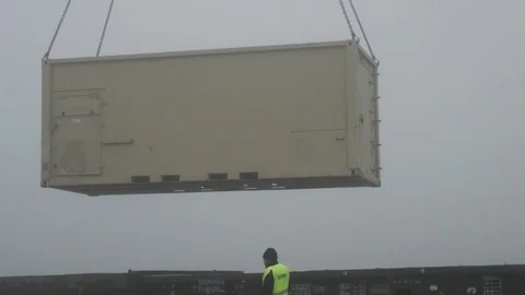 Steel container attached to chains being lifted onto trailer  Stock Footage 84254951