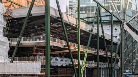 Steel Frame Structure and Workers on Active Construction Site Stock Photos