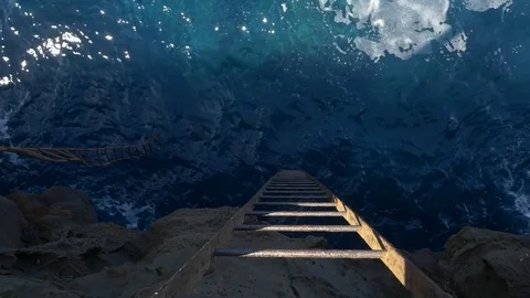 A steel ladder going down a cliff into the sea Stock Footage 84894600