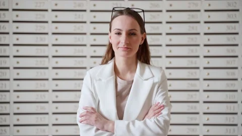 Steel mailboxes in an apartment building. Rows of numbered mailboxes. A woman Stock Footage 239669384