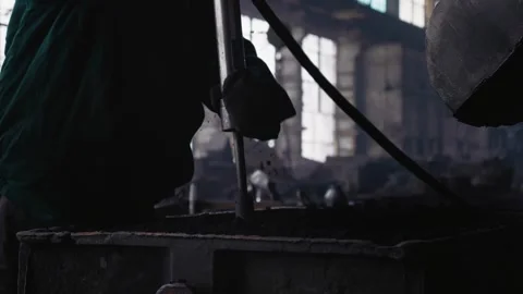 Steel making process of man tapping sand into the casts. Stock Footage 296542613