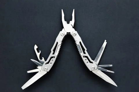 Steel multitool multi function tool on dark background, close-up. Stock Photos