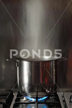 Steel pot boiling on fire Stock Photos