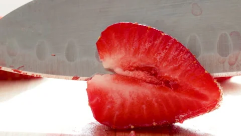 Steel sharp knife cutting a tasty red delicious strawberry 動画素材 197640170