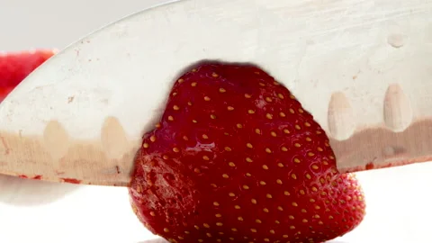 Steel sharp knife cutting a tasty red delicious strawberry Stock Footage 197640491