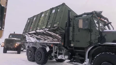 Steel shipping container loading on to medium tactical vehicle during snowfall Stock Footage 265154488