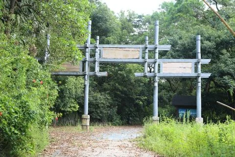 A steel structure gate with two large signs on the side of it is located in.. Stock Photos