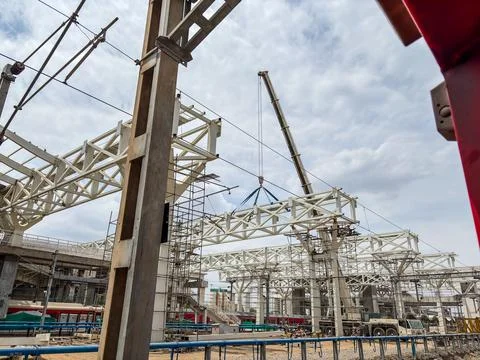 Steel structure installation using crane at construction site with workers .. Stock Photos
