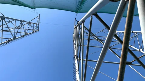 Steel structures low angle shot with blue sky and a fighter jet passing by.  Stock Footage 130158356