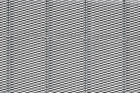 Steel surface with a repeated, geometric pattern of perforations resembling.. Stock Photos