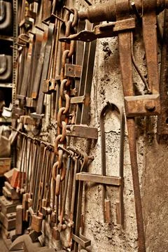 Steel, tools and workshop with blacksmith workplace and industrial factory wall Stock Photos