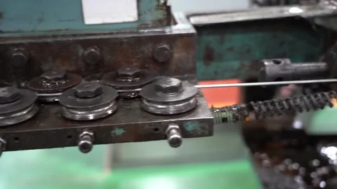 Steel wire feeds through roller straighteners into a green thread rolling Видео 346738030