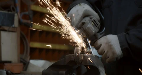 Steel worker with angle grinder making hot glowing sparks Stock Footage 120619410