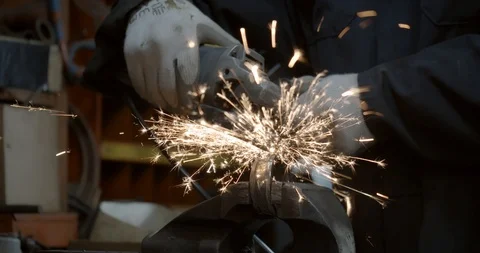 Steel worker with angle grinder making hot glowing sparks Stock Footage 120619436