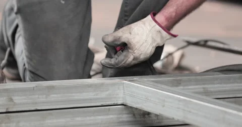Steel Worker Assembling Metal Frame Made Of GI Tubular - close up Stock Footage 142697830