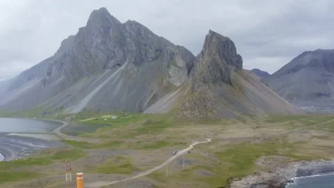 Steep and colored mountain Eystrahorn with seashore and lighthouse Stock Footage 138709356