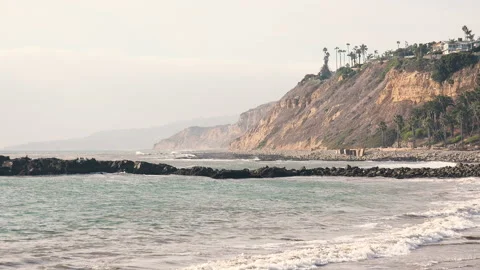 Steep bluffs rising from the Pacific Ocean at a tropical resort Stock Footage 134588269