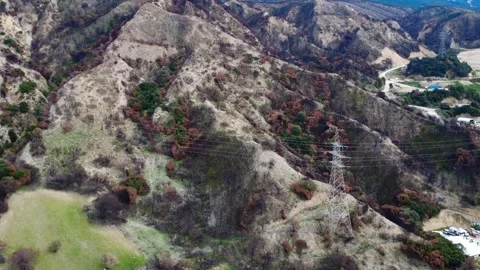 Steep burned mountain landscape with high voltage transmission tower structure Stock Footage 344096437