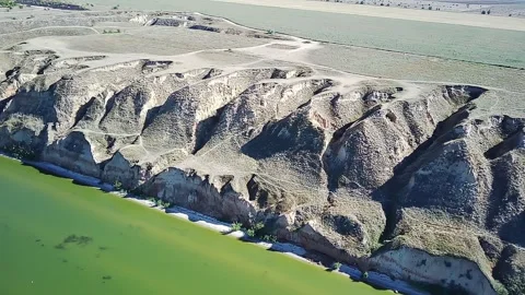 Steep Clay Cliffs Above the Malachite Water of the Estuary  Flooded with Sun Video stock 318072668