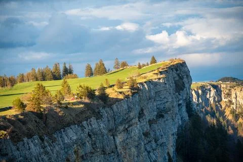 A steep cliff under cloudy sky Фото