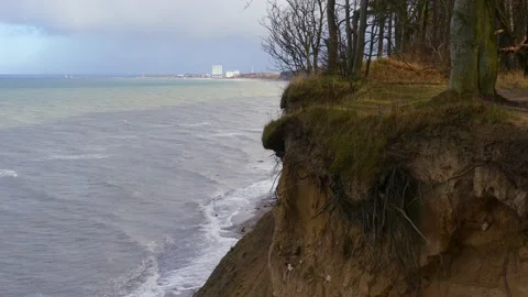 Steep coast with forest - view of ocean waves, beach, horizon and architecture Stock Footage 143588748