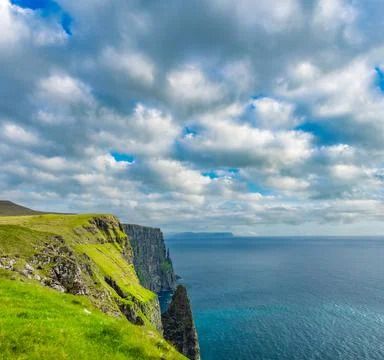 Steep coastline over the cliffs with sharp boulders Stock Photos