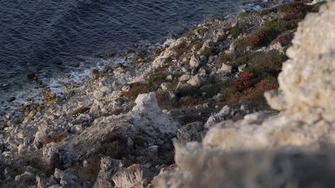 Steep descent from the cliff. The sea is calm and dark Video stock 125395385