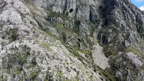 Steep dolomite cliff and rockfall overgrown with trees near Kotor, Montenegro Stock Footage 153679639