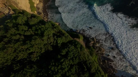 Steep FPV Drone Dive Above Coastal Forest And Rocky Shore At Karang Boma Cliff, Stock Footage 336636495